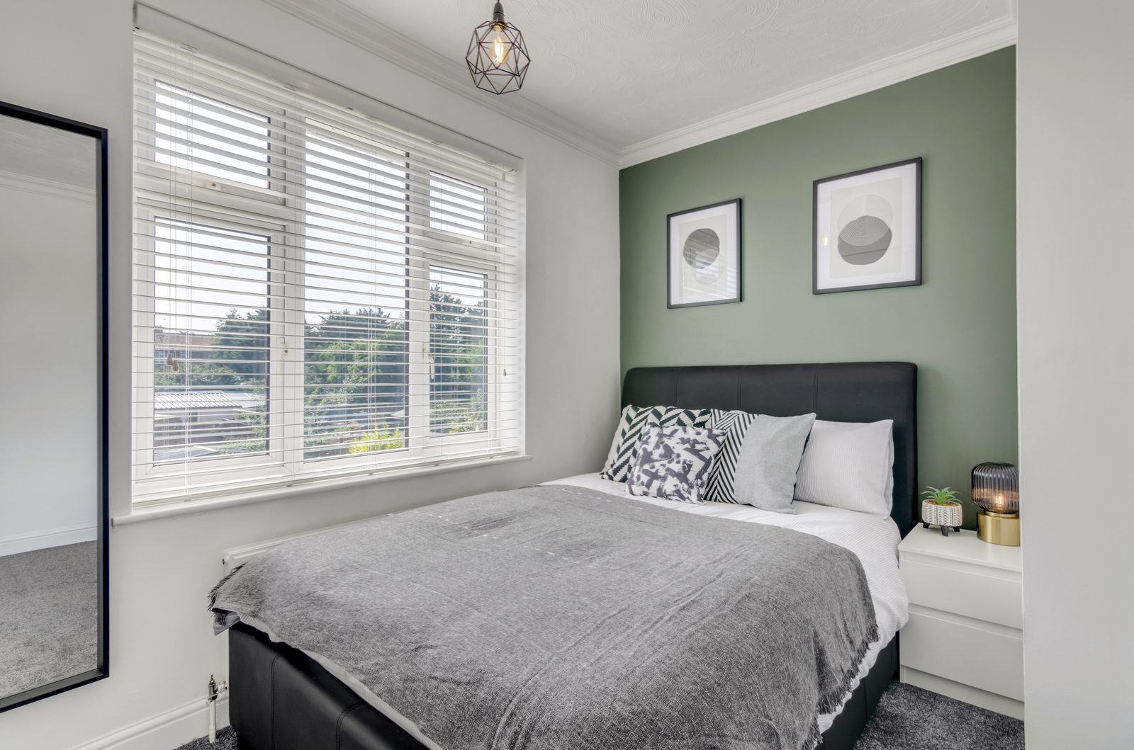 Bedroom with sage green feature wall at Horning Close